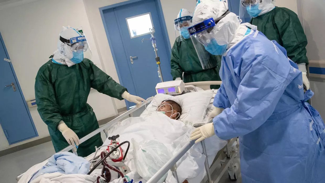 patient surrounded by doctors wearing PPE